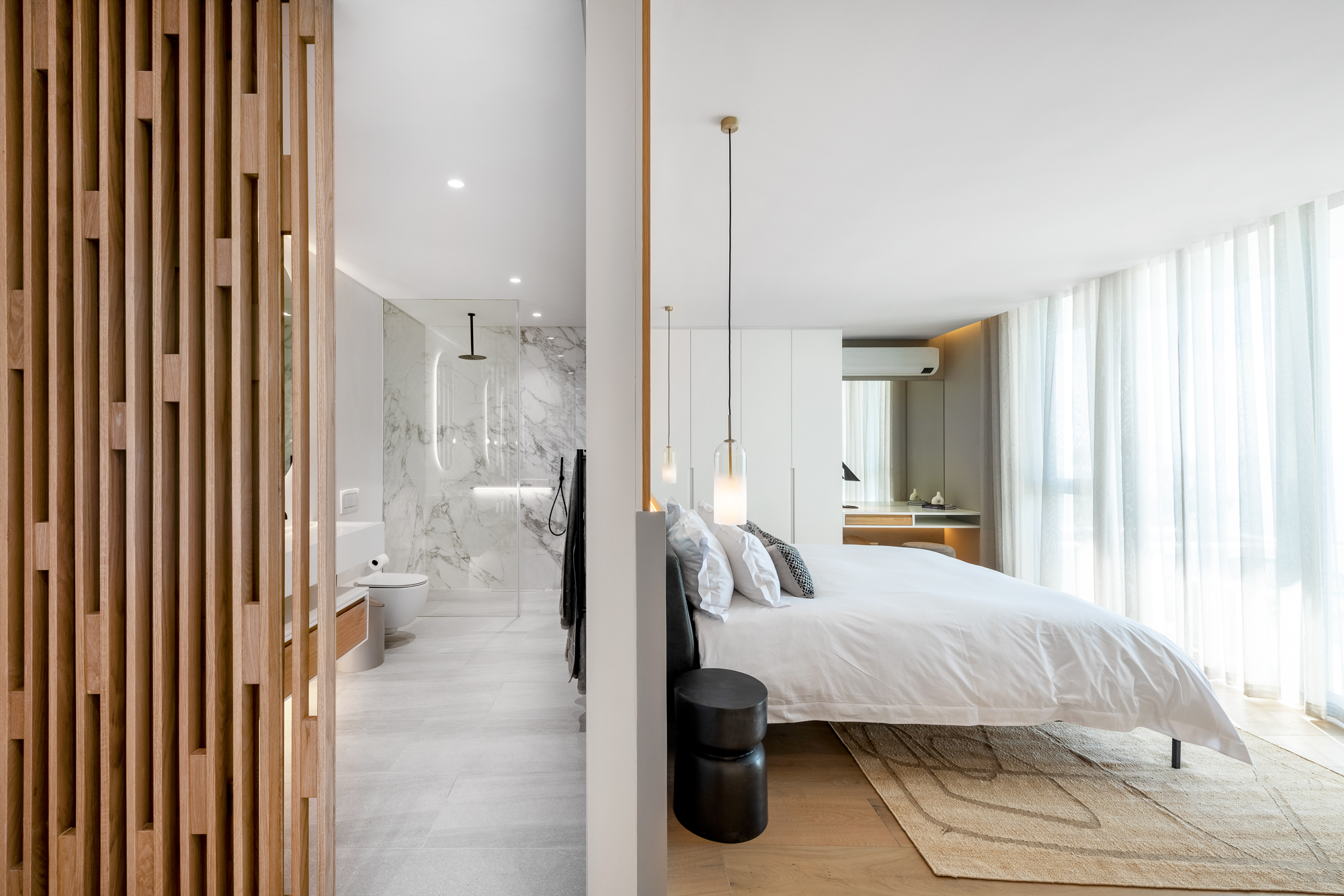 Luna Suite bedroom and bathroom through the wood-slat room divider – Riva One, Camps Bay