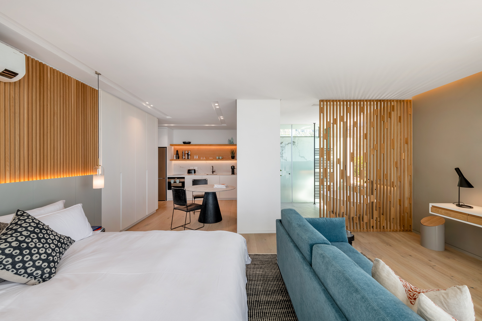 Mare Suite living area with wood-slat headboard and kitchenette – Riva One, Camps Bay