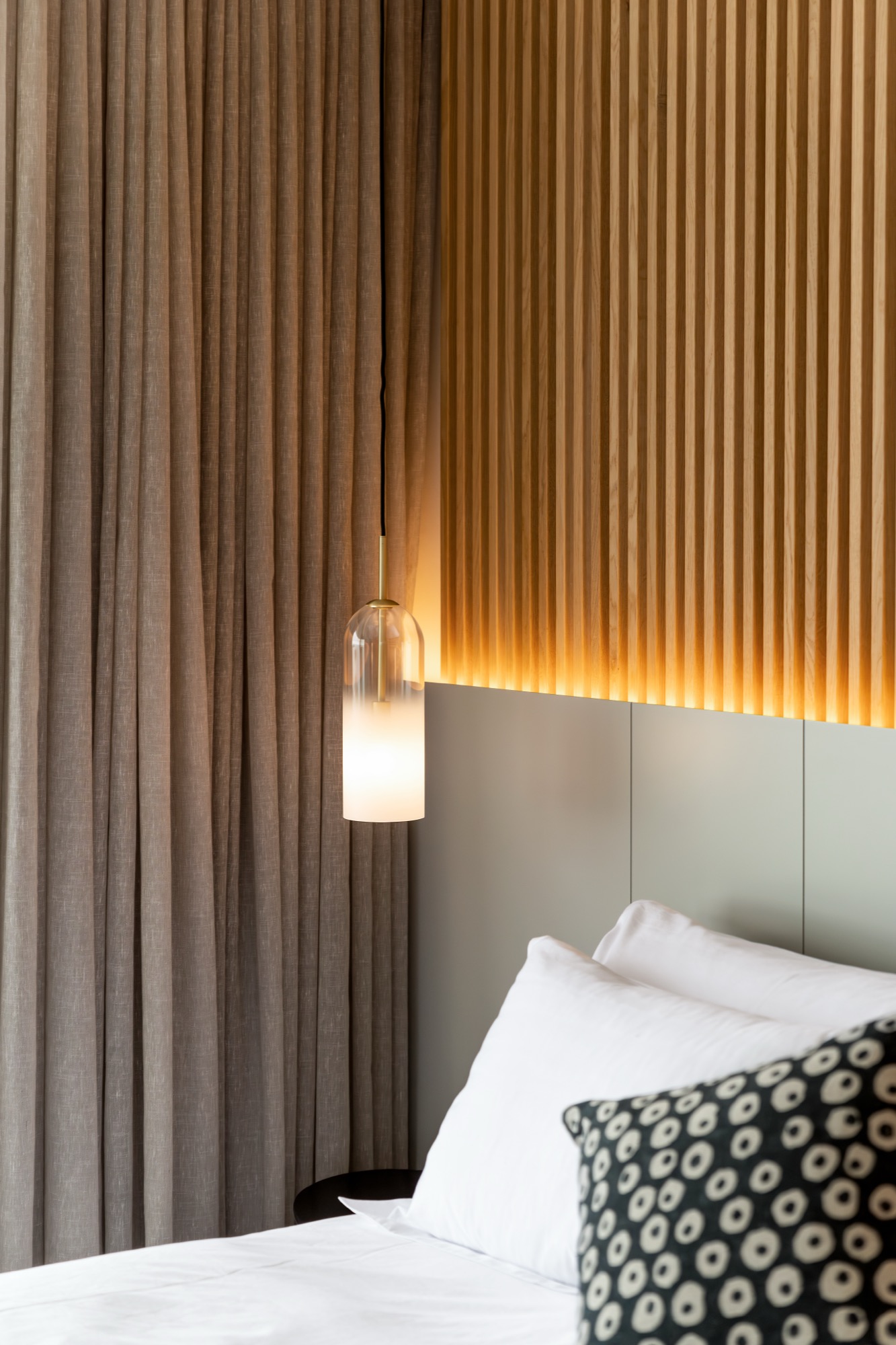 Mare Suite bedside pendant lamp against the wood-slat wall – Riva One, Camps Bay