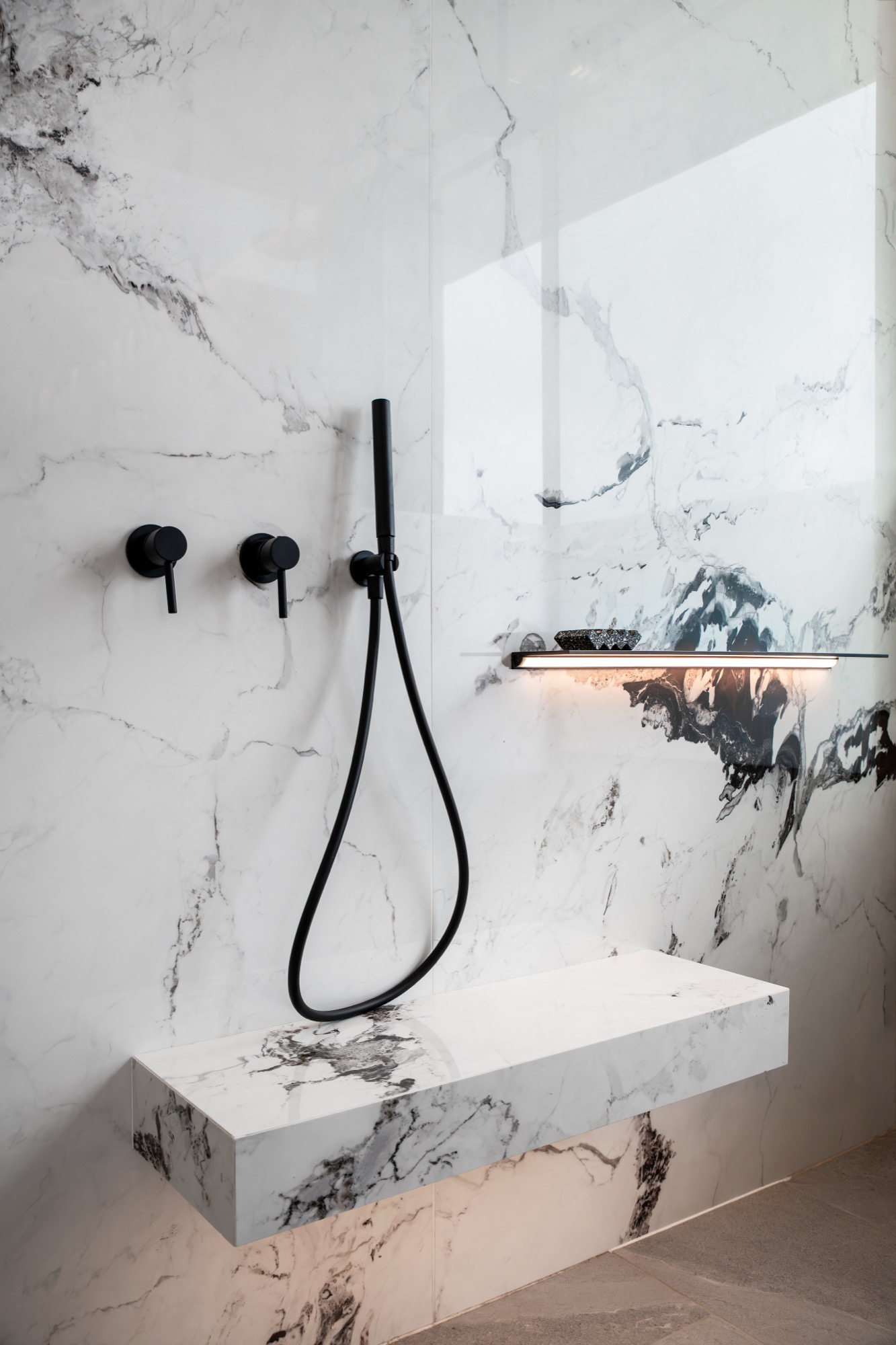 Mare Suite walk-in shower with black fittings and marble walls – Riva One, Camps Bay