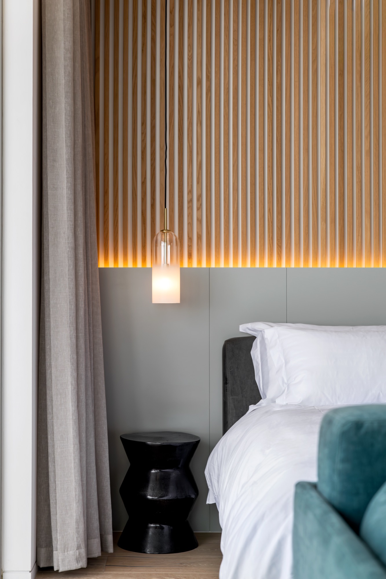 Mare Suite bedside pendant lamp against the wood-slat headboard – Riva One, Camps Bay
