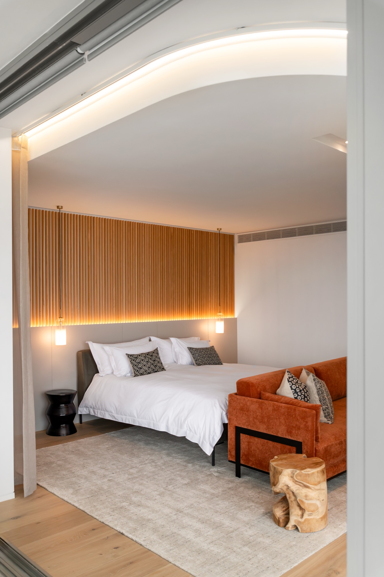 Sole Suite bed and lounge area with cove-lit ceiling – Riva One, Camps Bay