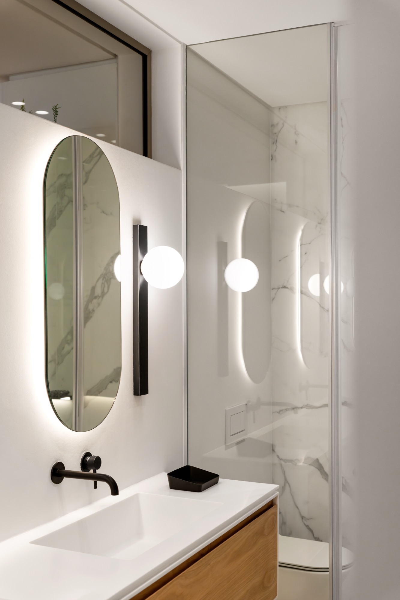Sole Suite en-suite bathroom with oval mirror and glass-walled shower – Riva One, Camps Bay